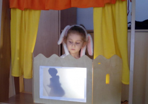 Dziewczynka w roli aktora w teatrzyku cieni.